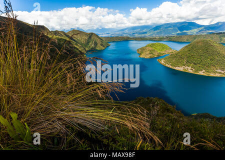 Cuicocha, beau lagon bleu dans l'intérieur du cratère du volcan Cotacachi les pointes avec de l'herbe au premier plan Banque D'Images