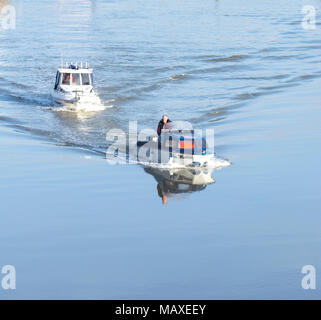 Deux petits bateaux à moteur se déplaçant lentement sur les eaux encore Banque D'Images