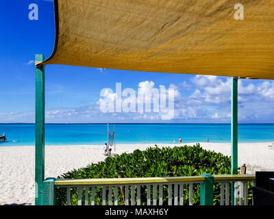 Vue depuis la cabine de plage avec de l'eau turquoise à Grace Bay, Providenciales, Îles Turques et Caïques. Toile verte sur la structure. Banque D'Images