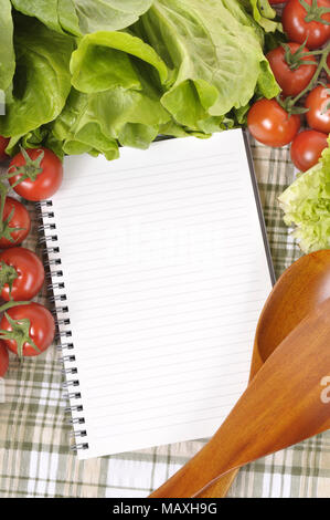 Sélection de salades avec livre de recettes ou liste de courses et en bois servant de cuillères. Banque D'Images