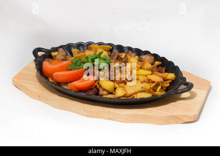 Pommes de terre viande frite dans une poêle sur un arbre l'oignon sur un fond blanc Banque D'Images