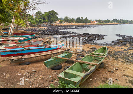 Les pirogues de pêche en bois coloré de ce village de pêcheurs à Sao Tomé se trouvent sur la plage à l'aube, prêt à l'emploi comme la lumière du jour se lève. Banque D'Images