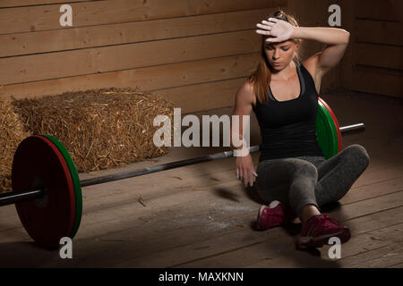 Jeune femme active de la sueur de balayage après entraînement de fitness - power lifter le repos Banque D'Images