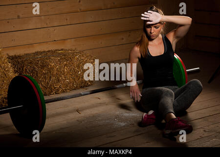 Jeune femme active de la sueur de balayage après entraînement de fitness - power lifter le repos Banque D'Images