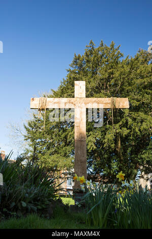 Croix de bois à Pâques dans le parc de Sainte Marie la Vierge l'église, dans le contexte d'un grand arbre d'if Gillingham Dorset England UK Banque D'Images