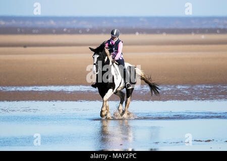 Plage d'Ainsdale, Southport, Merseyside. 5e avril 2018. Soleil et ciel bleu sont des conditions météorologiques parfaites pour Josie Williams de prendre son cheval bien-aimé, 15 ans fumisterie, pour un galop sur le sable doré et la marée montante sur la plage d'Ainsdale à Southport, Merseyside. Credit : Cernan Elias/Alamy Live News Banque D'Images