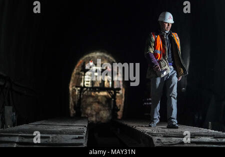 (180405) -- ALTUN, montagnes, 5 avril 2018 (Xinhua) -- Builder Du Yong travaille dans un site de construction du chemin de fer dans la Golmud-Korla Altun, montagnes du nord-ouest de la Chine, la Région autonome du Xinjiang Uygur, le 4 avril 2018. Les 1 213 km de long, la ligne reliant Golmud au Qinghai et au Xinjiang Korla, est le troisième de l'artère ferroviaire reliant le Xinjiang avec les provinces voisines. La construction de la ligne Golmud-Korla a commencé en 2014, et le projet est prévu pour durer cinq ans. La ligne se coupe la circulation entre Golmud et Korla à partir de 26 heures à 12 heures. (Xinhua/Jiang Wenyao) (2004) Banque D'Images