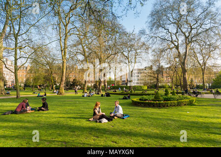 Des gens assis sur l'herbe à Russell Square, Bloomsbury, London, UK Banque D'Images
