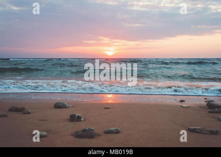 Vue panoramique de beau lever de soleil au-dessus de la mer. Des pierres sur le sable sur la plage, dans la lumière du matin, passant de l'seaIndia, Goa, Kerala, Asie, Indi Banque D'Images