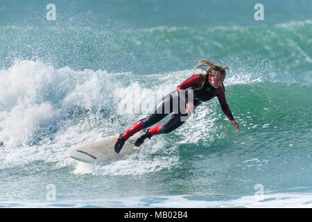 Un surfeur chute depuis une planche de surf dans des conditions hivernales à froid dans Fistral Newquay en Cornouailles. Banque D'Images