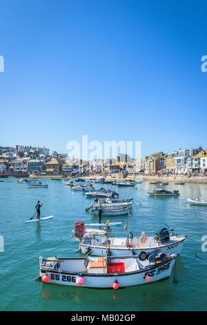 Divers bateaux et canots amarrés à marée haute dans le port de St Ives en Cornouailles. Banque D'Images