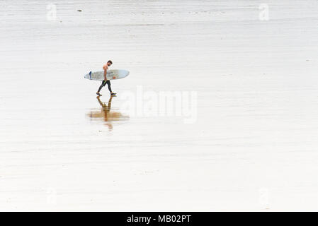 Une famille surfer carrying surfboard et marchant sur une plage de Fistral à Newquay en Cornouailles. Banque D'Images