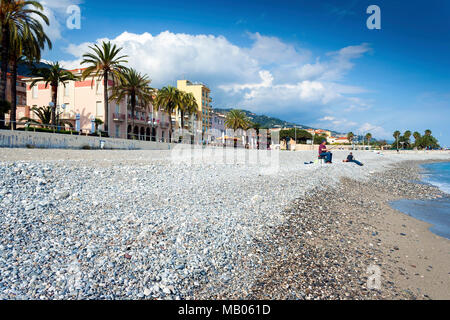 Menton, Cote d'Azur, France - 15 mai 2009 : Menton front de mer et plage avec un pêcheur sur une chaude journée d'été Banque D'Images