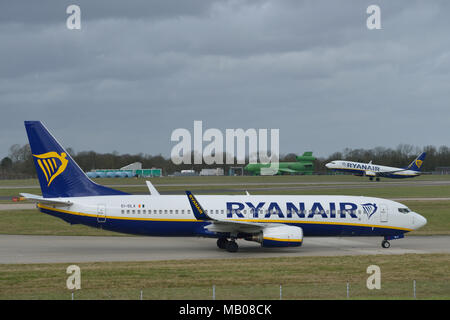 Le roulage des avions de Ryanair à l'aéroport de Londres Stansted Ryanair comme un autre avion décolle dans l'arrière-plan Banque D'Images