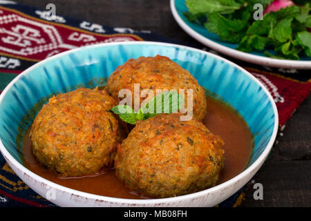 Close up of Koofteh Tabrizi Grandes boulettes farcies aux fruits secs, les baies et les noix dans un bouillon de tomate Curcuma azérie iranienne traditionnelle et plat Banque D'Images