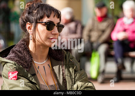 Dans le centre-ville de Dundee, une charmante femme portant des lunettes de soleil est assise au soleil pour être photographiée, en Écosse Banque D'Images