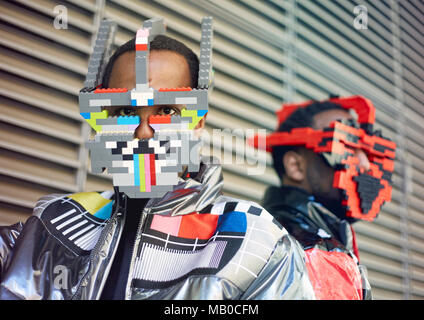 Peter (à gauche) et Paul Allimadi portant des vestes par L4L'habillement et les masques de lego par Bwoywonder qu'ils participent à la Semaine de la mode de Londres. Banque D'Images