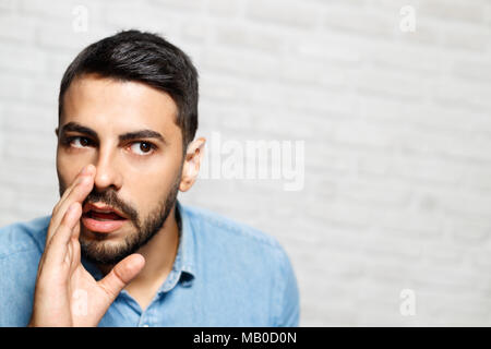 Les expressions du visage de jeune homme Barbe sur mur de brique Banque D'Images