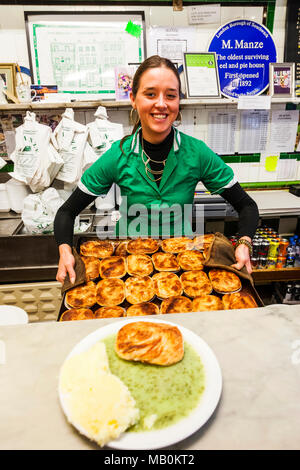 L'Angleterre, Londres, Southwark, Manze Pie et Mash Shop, sous-Holding Tray of Pies Banque D'Images