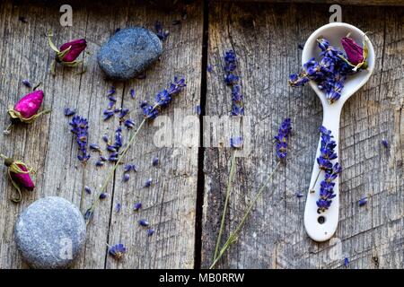 Et lavande séchées et de fleurs de rose sauvage, de céramique et de pierres sur scoop vintage en bois - fond fond de fines herbes Banque D'Images