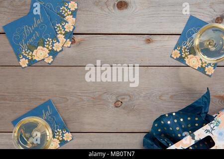 Floral bleu douche nuptiale rustique avec des décorations de table en verre de vin et un sac-cadeau sur fond de bois. Banque D'Images