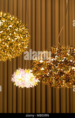 La pendaison de fantaisie avec des lampes d'or métallique sur un fond de mur rideau marron à l'intérieur. Banque D'Images