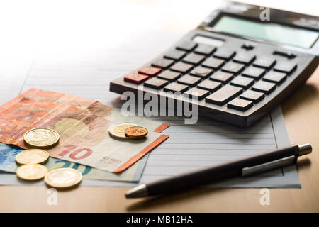 Stylo et calculatrice sur la table de l'argent comptant Banque D'Images