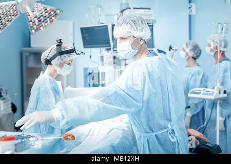 Belle homme sérieux en tenant un instrument médical Banque D'Images