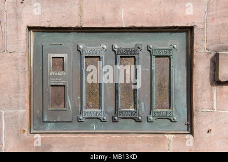 Distributeur de timbres-poste mural vintage avec plusieurs fentes, serti dans la pierre, d'un bureau de poste britannique historique Banque D'Images