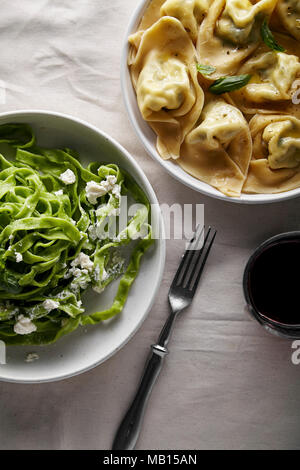 Raviolis italiens traditionnels à base de ricotta et épinards tagliatelle servi avec un verre de vin rouge Banque D'Images
