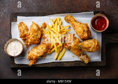 Cuisses de poulet pané frit avec sauce de restauration rapide populaires sur fond brun Banque D'Images