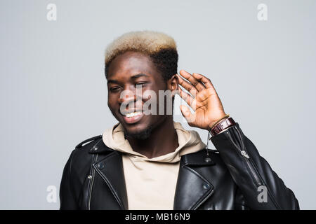 Portrait d'un homme curieux d'essayer d'entendre quelque chose tout en gardant la main à son oreille isolé sur fond blanc Banque D'Images