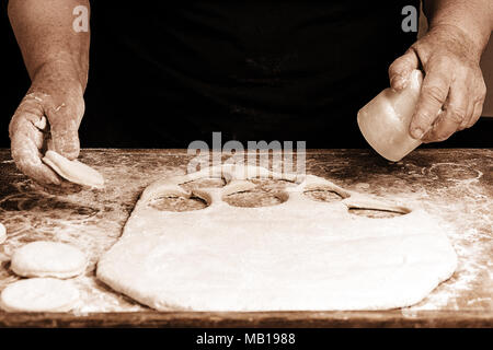 Granny serre un verre d'un cercle dans une pâte sur la table 2018 Banque D'Images
