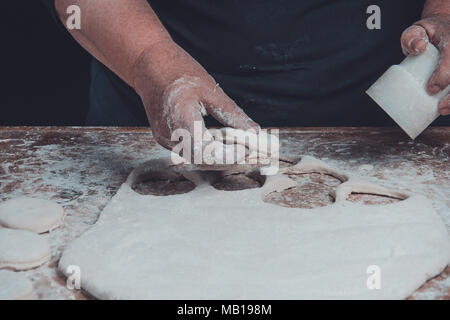 Granny serre un verre d'un cercle dans une pâte sur la table 2018 Banque D'Images