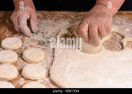 Granny serre un verre d'un cercle dans une pâte sur la table 2018 Banque D'Images