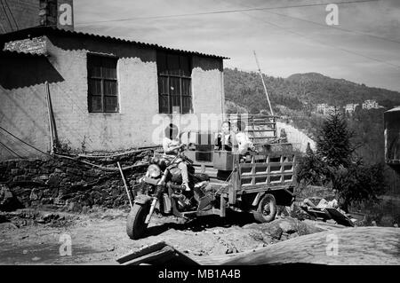 Duo Yi Shu Village, Yunnan, Chine - 26 décembre 2017 : les enfants jouant sur le tracteur près d'un bâtiment abandonné Banque D'Images