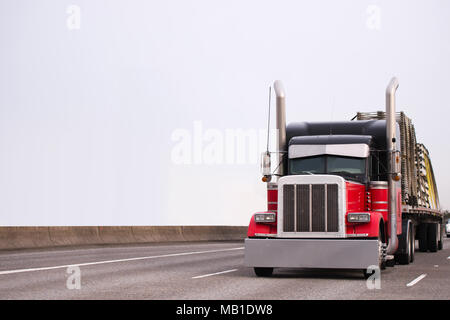 Classique américain professionnel puissant populaire modèle noir et rouge gros camion semi truck avec d'énormes tuyaux d'échappement et garniture chromée trans accessoires Banque D'Images