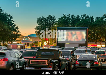 Regarder des films en plein air à partir de la voiture dans la ville stationnement sur une chaude nuit d'été Banque D'Images