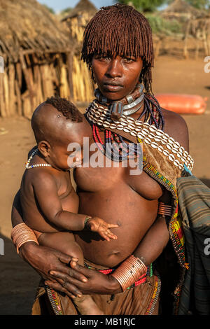 Turmi, Éthiopie - le 25 janvier 2018 : femme tribu Hamer non identifié avec son fils. Hamer femme peigne généralement leurs cheveux avec de la terre à Turmi, Éthiopie. Banque D'Images