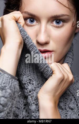 Portrait de beauté de jeune femme en laine gris. Fille brune avec des yeux bleus et des femmes journée maquillage. Banque D'Images