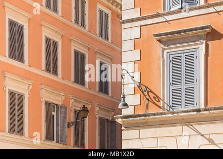 Deux styles de lampes sur les bâtiments au-dessus d'un coin de rue à Rome, Italie. Banque D'Images