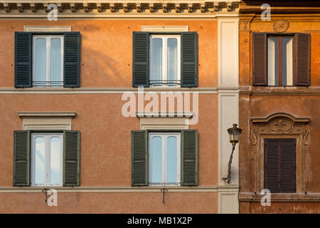 Une plaque au-dessus de sun une des fenêtres sur un bâtiment à Rome, Italie, en tant qu'il attrape le dernier des jours du soleil. Banque D'Images