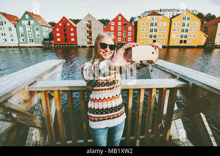 Happy smiling woman taking voyageant en selfies Trondheim Norvège ville vie vacances week-end en plein air maisons de mode scandinave repères archit Banque D'Images