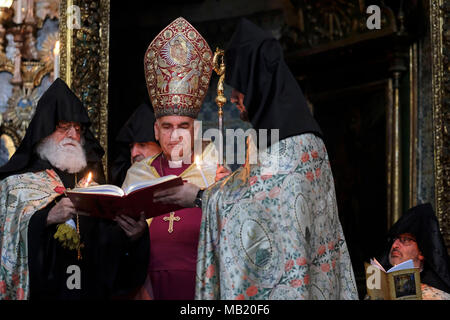 Les prêtres arméniens tenant la bible de l'évêque anglican à Jérusalem Suheil Dawani lorsqu'ils participent à la cérémonie Maundy le jeudi Saint, Le jour Saint chrétien avant la Pâques orthodoxe qui commémore la dernière Cène de Jésus-Christ avec les Apôtres à la Cathédrale Saint-Jacques la principale église du Patriarcat arménien de Jérusalem située dans le quartier arménien la vieille ville de Jérusalem-est. Israël Banque D'Images