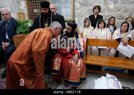 Jérusalem, Israël, le 5 avril 2018. L'archevêque orthodoxe syrienne, Mar Swerios Malki Murad, offre sa croix pour être embrassé par des prêtres au cours de la cérémonie de lavage des pieds le Jeudi Saint, avant la Pâque orthodoxe qui commémore la Dernière Cène de Jésus Christ avec les Apôtres à l'intérieur de San Marcos ou église Saint Marc au centre de la communauté syriaque orthodoxe où les prières sont menées en langue Aramic situé dans la vieille ville de Jérusalem-Est Israël Banque D'Images