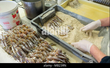 27 mars 2018, l'Allemagne, l'Hoopte : un cuisinier l'éperlan manteaux de chapelure. Après quatre décennies dans le travail, pêcheur Wilhelm Grube craint pour l'avenir, comme ces poissons sont devenus incroyablement rare. Photo : Philipp Schulze/dpa Banque D'Images