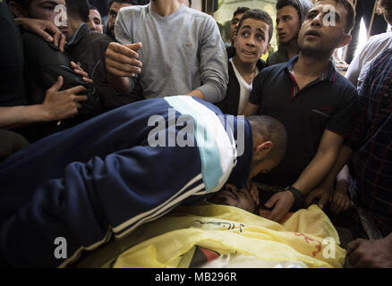 La ville de Gaza, la bande de Gaza, en Palestine. 6ème apr 2018. Des proches de 30 ans, Thaer Rabaa, tué par des soldats israéliens au cours de la protestation en cours le long de la frontière de Gaza avec Israël, pleurer lors de ses funérailles dans le camp de réfugiés de Jabalya dans le nord de la bande de Gaza le 6 avril 2018. Credit : Mahmoud Issa/Quds Net News Wire/ZUMA/Alamy Live News Banque D'Images