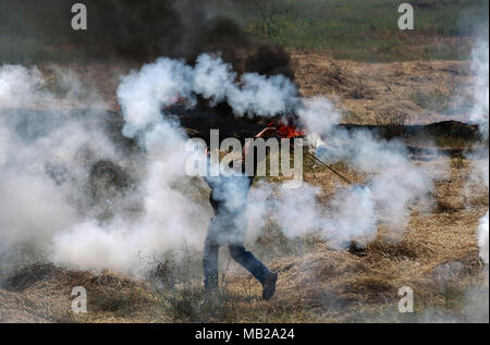 (180406) -- GAZA, 6 avril 2018 (Xinhua) -- un manifestant palestinien utilise une fronde pour lancer des pierres sur des soldats israéliens lors d'affrontements sur la frontière Gaza-Israel, est de la ville de Gaza, le 6 avril 2018. Des centaines de manifestants palestiniens ont commencé vendredi pour mettre le feu à des dizaines de pneus de voiture près de la frontière entre l'est de Gaza et Israël dans une tentative de rendre un bouclier de fumée noire pour se protéger des tirs des soldats israéliens. (Xinhua/Stringer) (ZF) Banque D'Images