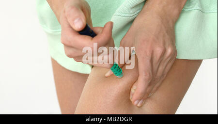 L'autonomie des femmes dans une injection d'insuline de la jambe à la jambe malade étant injecté à sa cuisse Banque D'Images