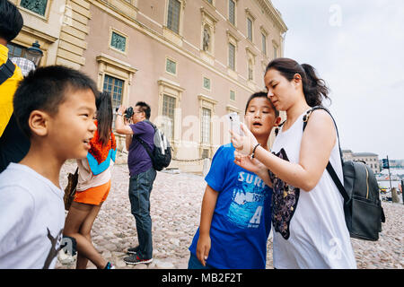 STOCKHOLM, Suède - 30 juillet 2014 : Asian family touristes visiter et photographier la garde d'honneur au Palais Royal à Gamla Stan, où le roi Charles XV Banque D'Images